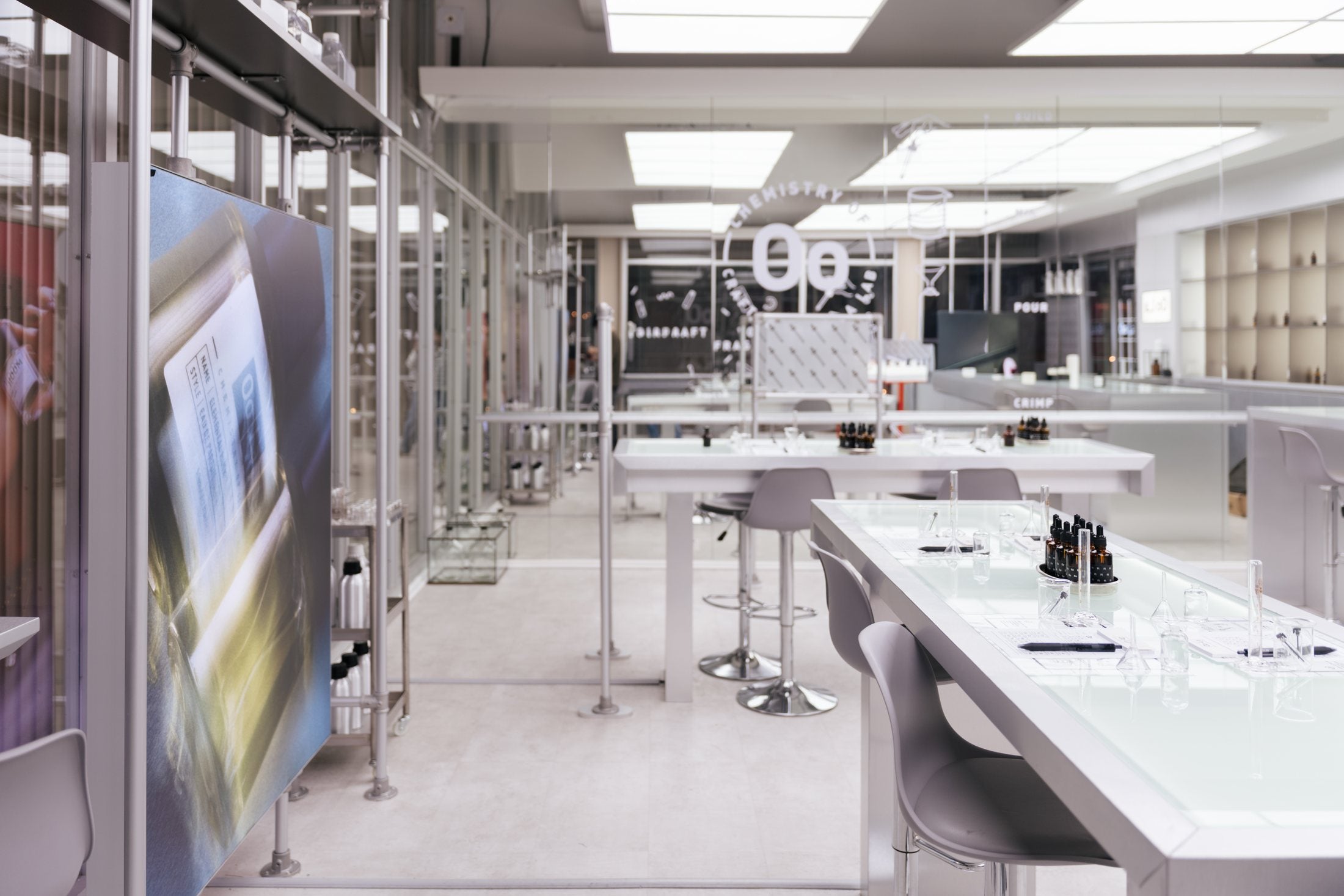 An empty, brightly lit fragrance studio seen from the entrance, with the work tables waiting.